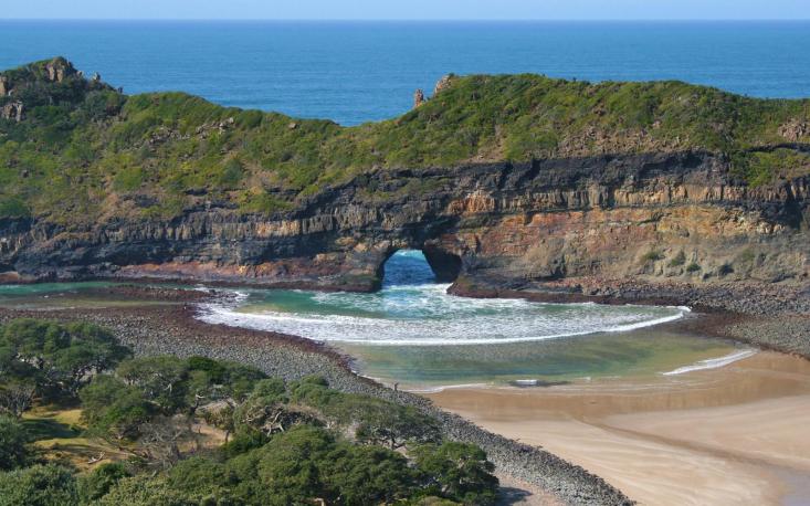 picture of eastern Cape  beach with a tidal island that has a hole